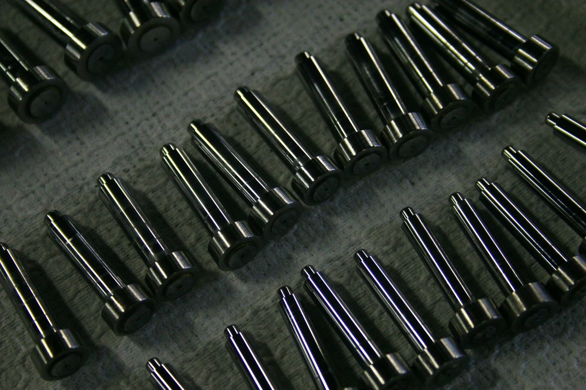 Precision machined steel shafts and pins with stepped diameters, produced by CNC turning